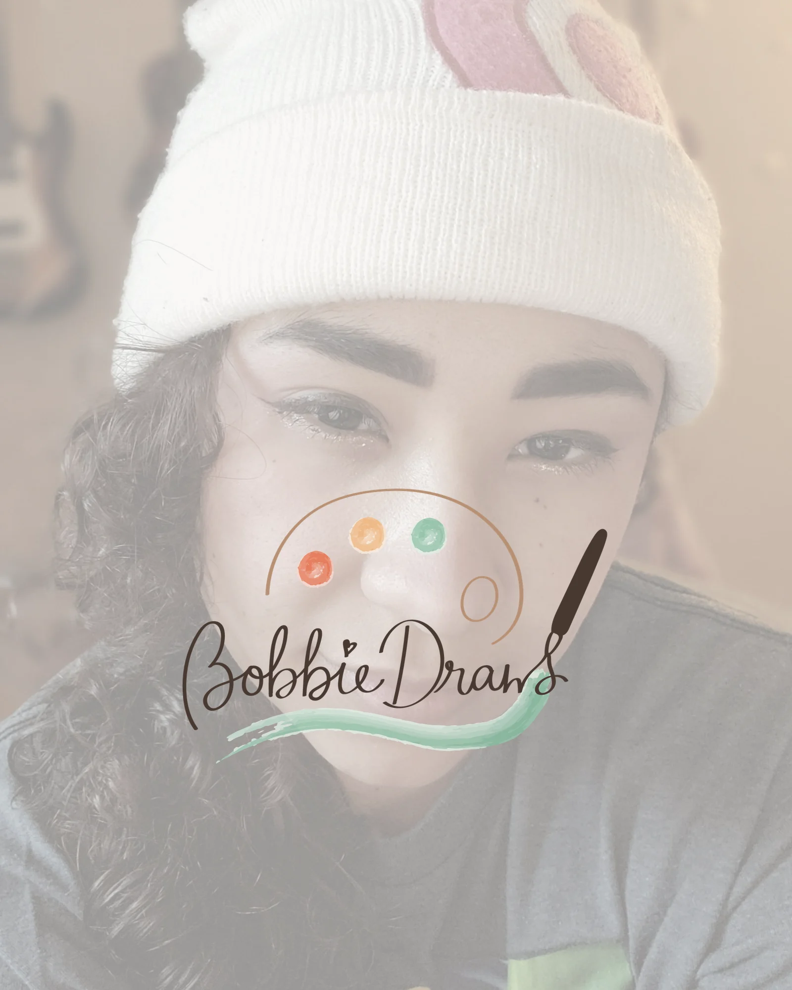 Bobbie's own Bobbie Draws mark, a script wordmark with a palette and brush, layered over a softened portrait of the artist